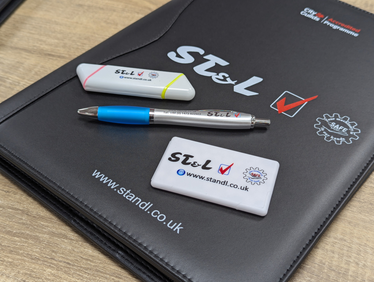 Branded Merchandise in Sudbury Suffolk ST & L branded folder, pen, USB drive, and name badge, customized for corporate use.