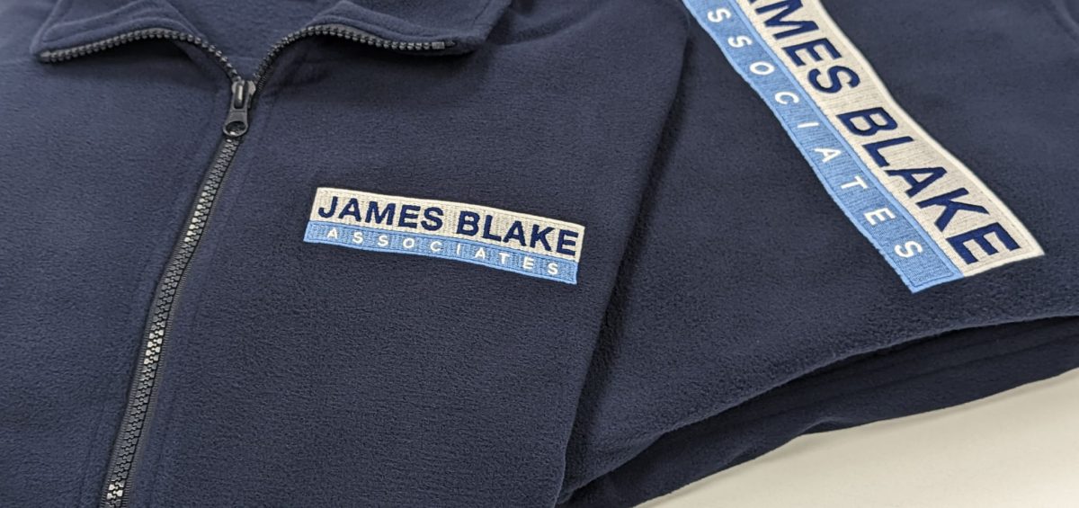 James Blake Associates branded navy fleece jackets, customised with their logo.