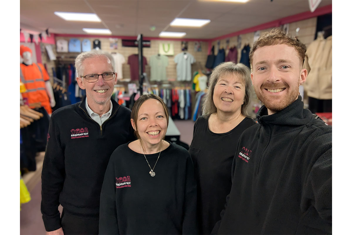 Top Marques Uniform Solutions team in their Sudbury showroom, surrounded by various workwear and uniform displays.