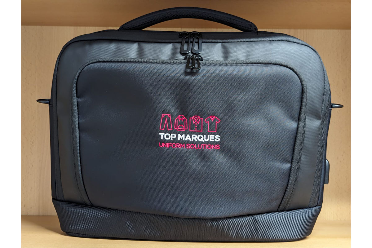 Top Marques Uniform Solutions branded black bag with pink logo.
