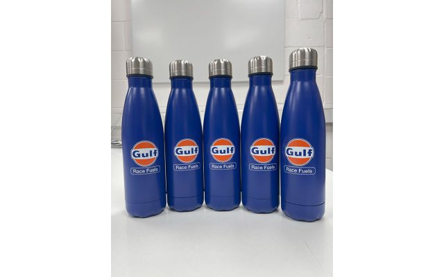 Customised dark blue reusable water bottles, each branded with the classic orange and white Gulf Race Fuels logo